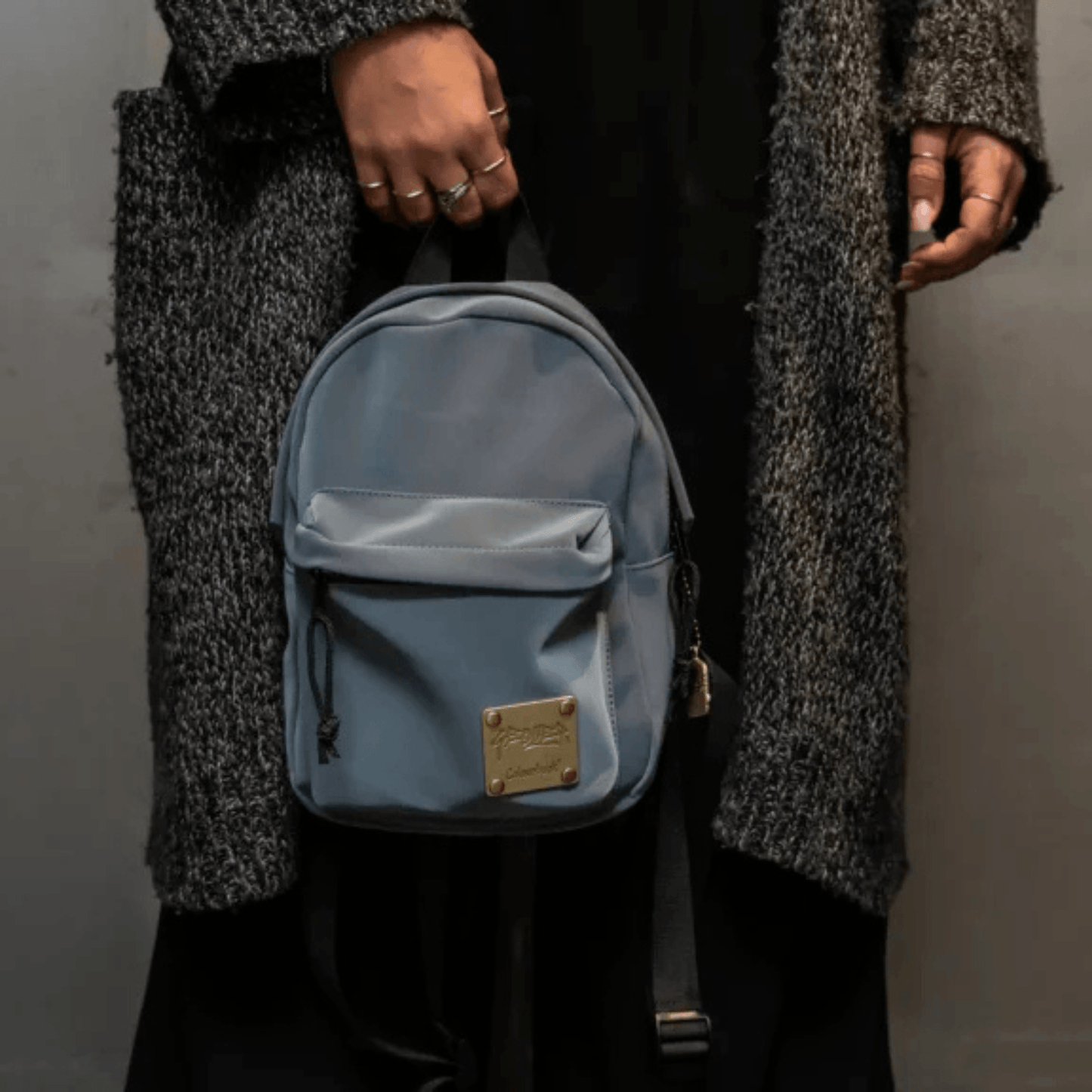 Mini zaino Geolier x Colourbook Drop Grey in Soft Velvet grigio, vista frontale con logo e targhetta in acciaio